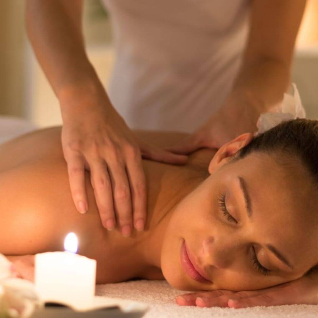 Massage oils on skin during massage treatment. relax during a candle lit massage and allow the treatment to soothe aches and pains and give your skin the love it deserves.