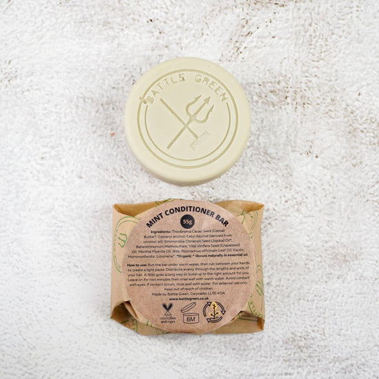 Battle Green Mint Conditioner Bar with bar on display with a fully wrapped bar. the packaging is compostable and printed with plant based ink. handmade in small batches, palm oil free, PETA certified Cruelty-Free & Vegan.