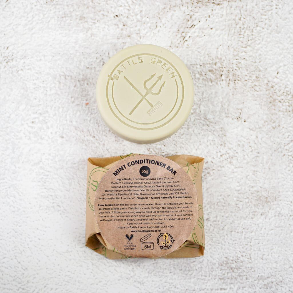 Battle Green Mint Conditioner Bar with bar on display with a fully wrapped bar. the packaging is compostable and printed with plant based ink. handmade in small batches, palm oil free, PETA certified Cruelty-Free & Vegan.