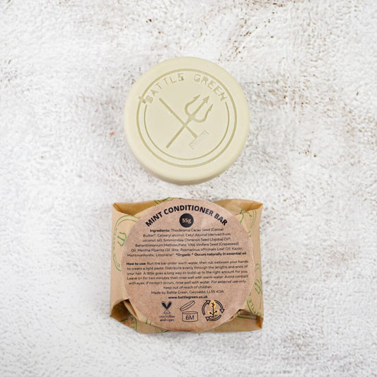Battle Green Mint Conditioner Bar with bar on display with a fully wrapped bar. the packaging is compostable and printed with plant based ink. handmade in small batches, palm oil free, PETA certified Cruelty-Free & Vegan.