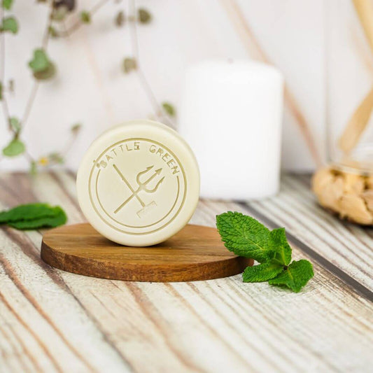 Battle Green Mint Conditioner Bar. uplifting and eco-friendly. On display on a wooden board. with Plastic Free Packaging.