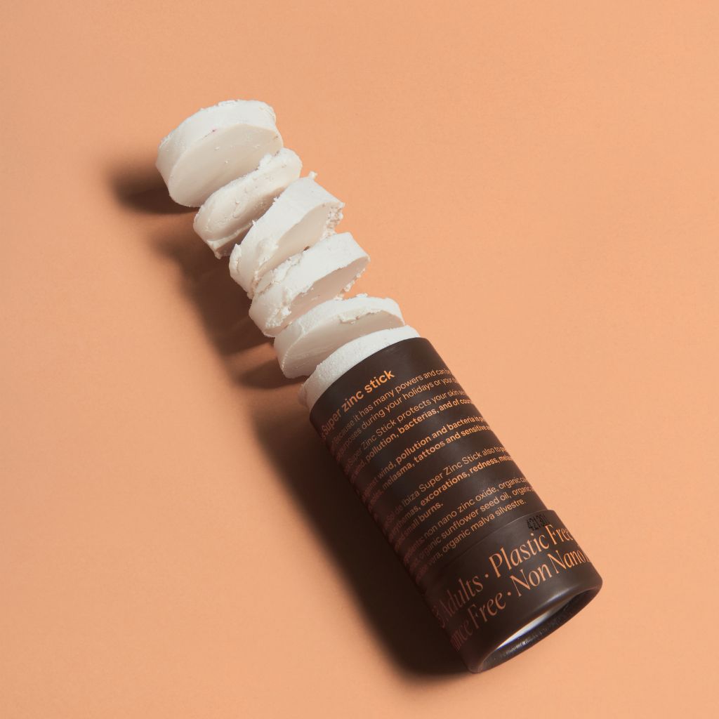 Sol de Ibiza Face & Body Plastic Free Zinc Stick SPF30 Sun screen. Cardboard tube. Natural, recyclable, vegan, cruelty free sun protection for all skin types, adults and children. flatlay with product texture.