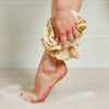 Tabitha Eve - Biodegradable Bath Pouf - Organic Cotton. GOTS certified natural Cotton. Made in UK. washing models foot. in use.