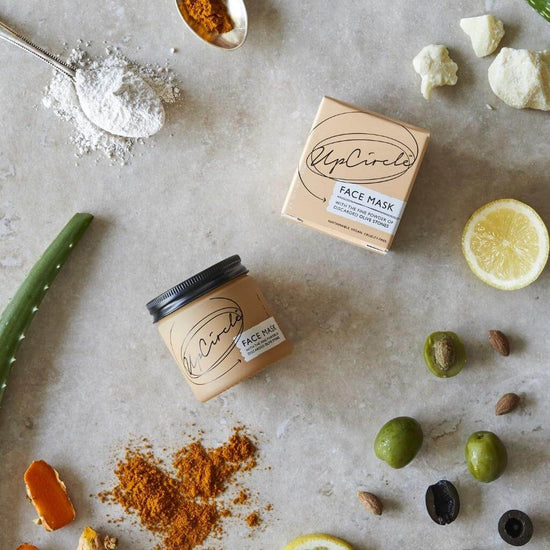 UpCircle - Kaolin Face Mask on a table with cardboard packaging, and incorporated raw ingredients all displayed.