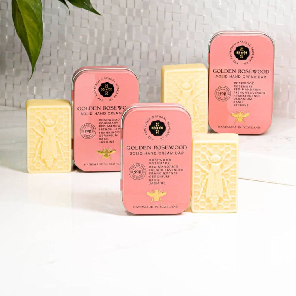The Edinburgh Natural Skincare Co. Golden Rosewood Solid Hand Cream Bar. On a shelf in a lifestyle display.