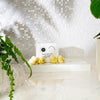 The Edinburgh Natural Skincare Co. Sweet Orange and Geranium Solid Bath Oils. Lifestyle on a table.