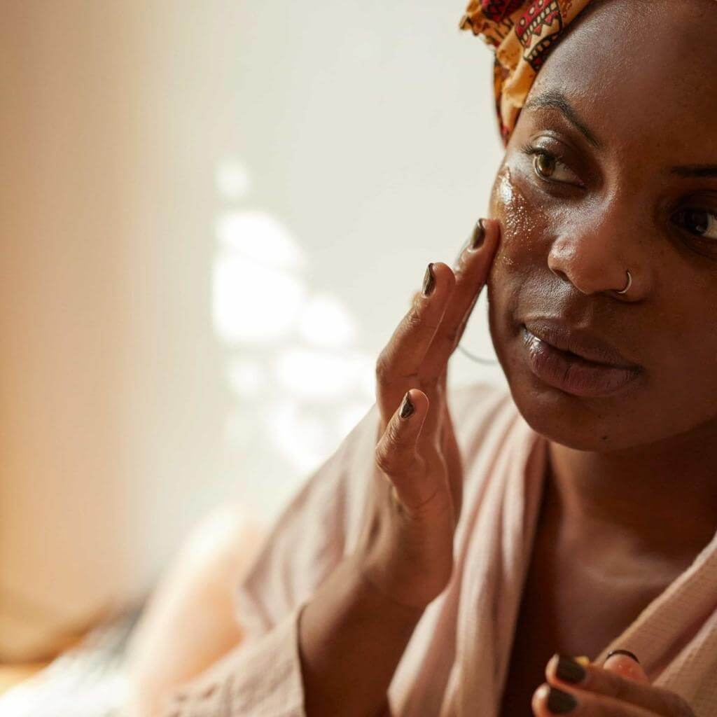 Upcircle Cleansing Face Balm being applied to a models face using her fingers.