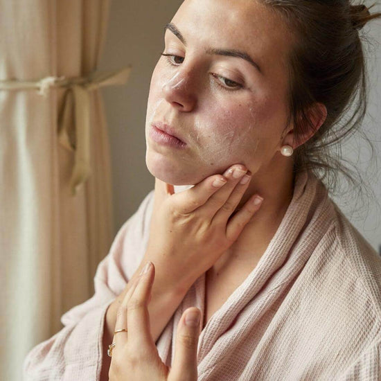 Upcircle Face Moisturiser being applied to a models face. She is rubbing it into her face.