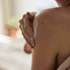 UpCircle - Body Cream being spread around on the upper arms and shoulders of a model.
