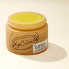 Upcircle Cleansing Face Balm without lid and bright yellow balm is visible. On a cream background with a distinct shadow.