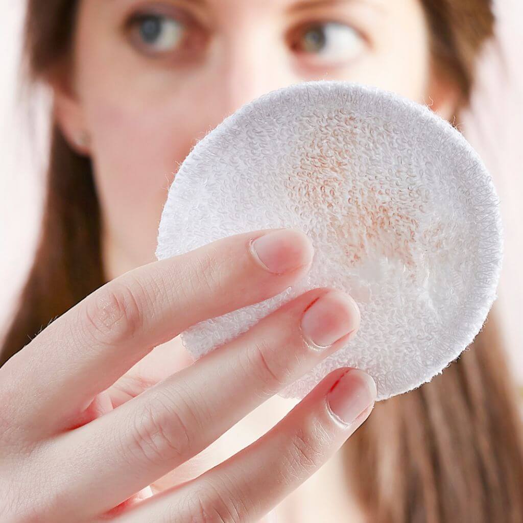 Tabitha Eve - Reusable Bamboo Make Up Pads Rounds - Set of 10. model holding pad with makeup on it. soft and the perfect way to update your face cleaning methods.