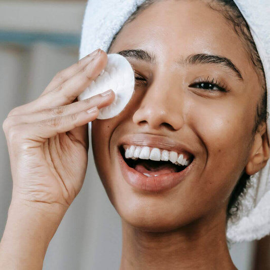 Flawless Professional Vegan Beauty Reusable Organic Cotton Makeup Remover Pads. Application on the face of a smiling model.