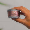 Orli Hair Treatment Candle - For Women in Aluminium tin being held by a hand. treat yourself to luscious locks.