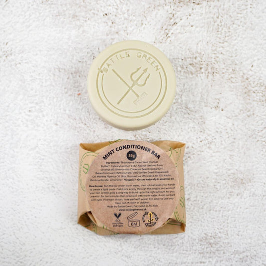  Battle Green Mint Conditioner Bar with bar on display with a fully wrapped bar. the packaging is compostable and printed with plant based ink. handmade in small batches, palm oil free, PETA certified Cruelty-Free & Vegan.