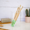 Battle Green Bamboo Toothbrush with Castor Oil Bio Bristles. on display with 4 toothbrushes in glass. on basin.