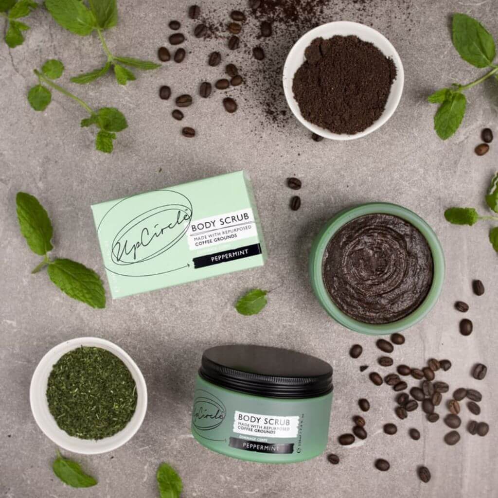 Upcircle Body Scrub with Peppermint jar and box on a table with the key raw ingredients on display.