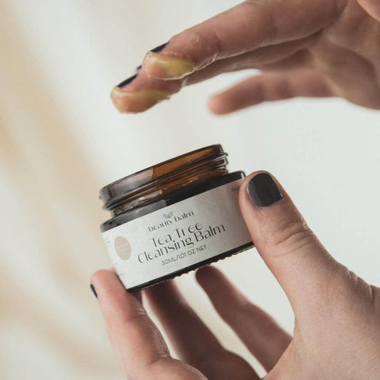 Beauty Balm Tea Tree Cleansing Balm. Lifestyle image with product on fingers. Smooth and light. perfect for cleaning makeup and impurities off the face.