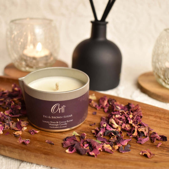 Orli Fig and Brown Sugar Massage Candle in Aluminium tin. Lifestyle Image with rose petals. Ready for melting.