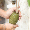 Fer à Cheval Olive of Marseille Soap on a Rope. Lifestyle. Soap hanging from running water tap and being used to wash hands.