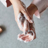 Upcircle Cinnamon and Ginger Soap foamed and lathered in the hands of a model.