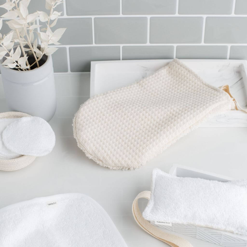 Tabitha Eve - Organic Cotton Shower Mitt. placed on the side of a bathroom. natural coloured and easily dried.