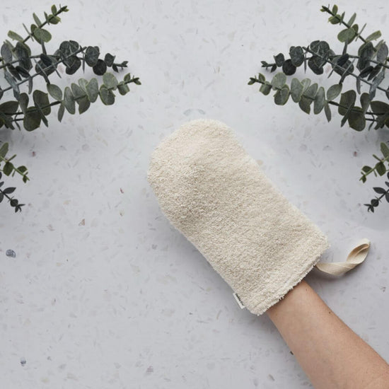 Tabitha Eve - Organic Cotton Shower Mitt. with hands in mitt. vegan, handmade in the uk. on the side of the bathroom.