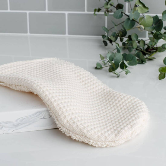 Tabitha Eve - Organic Cotton Shower Mitt. resting on the side of the bathroom. zero waste, washable, reusable.