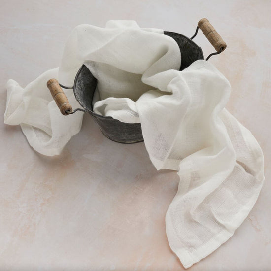 Tabitha Eve - Muslin Cloth. gentle to wipe away dirt and residue. perfect for babies. vegan and cruelty free. in a bucket on the floor.