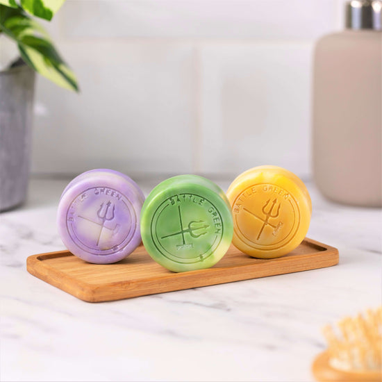 Battle Green Citrus Natural Vegan Shampoo Bar. with three other shampoo bars lined up. Affordable and effective way to buy shampoo. on wooden board.