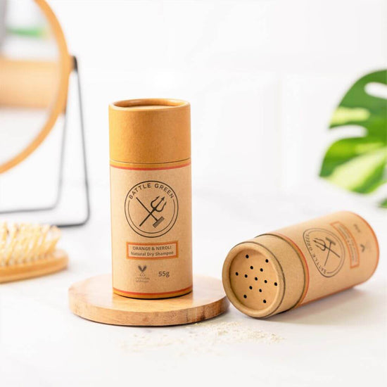 Battle Green Orange & Neroli Dry Shampoo Shaker Pot. Display with 2 pots. one with lid off showing the top of the cardboard tube, and one with lid on. Great for traveling and to boost volume in your hair.