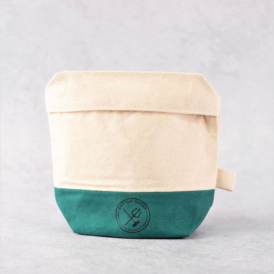 Battle Green certified Organic Cotton Wash Bag. on display. textured background. 2 tone colour, natural white cotton and green cotton.