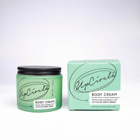UpCircle - Body Cream with the extract of leftover date seeds. Green Glass Jar and Cardboard packaging showing the front.