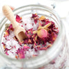 The Salt Parlour - Rose Geranium CALM Mineral Bath Salts in a glass jar, ready to be used. with visible rose geranium dried flowers.