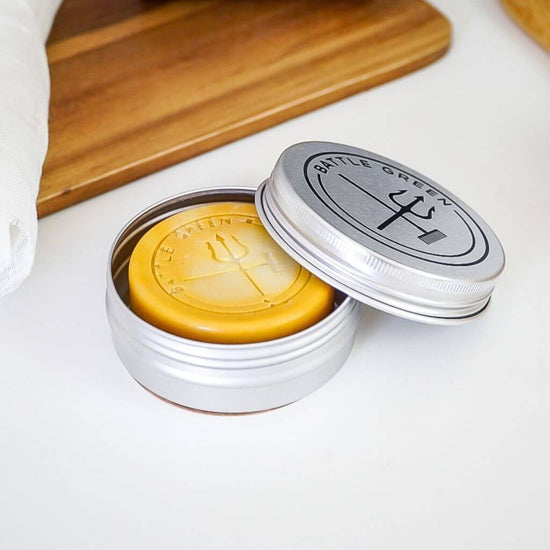 Battle Green Citrus Natural Vegan Shampoo Bar. on display in tin. the shampoo is 100% natural and is equal to 2-3 shampoo bottles.