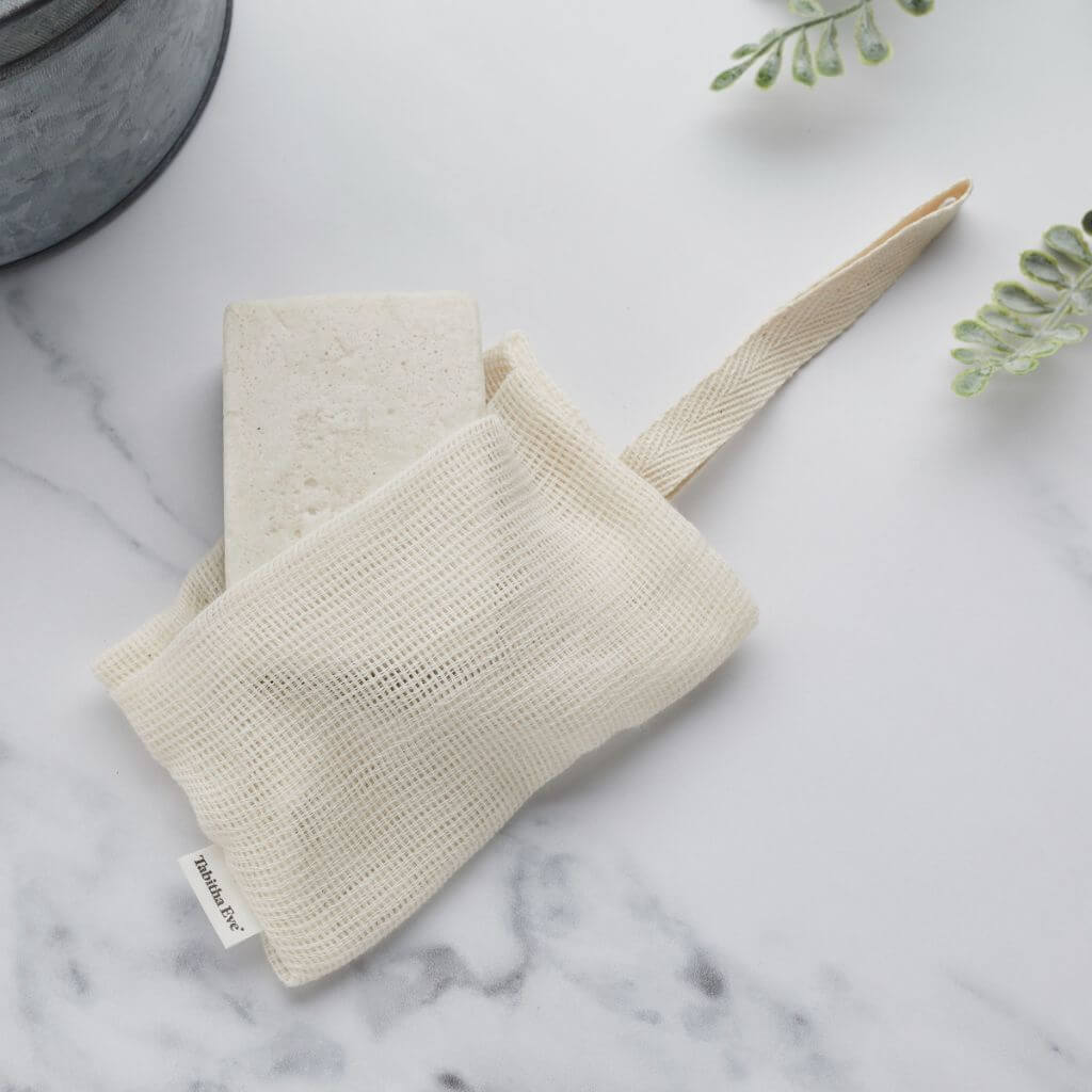 Tabitha Eve - Organic Cotton Soap Saver - biodegradable, sustainably sourced organic cotton. on table. Natural colour cotton with hanging strap.