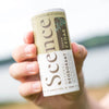 Scence Fresh Cedar Natural Solid Deodorant. Lifestyle Image, product being held outdoors. Vegan Certified. made in Cornwall UK. Size: 75 grams.