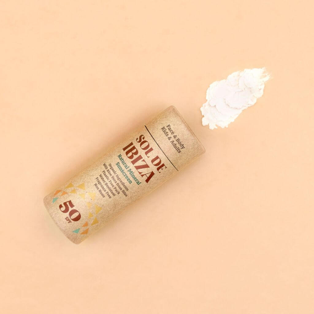Sol de Ibiza Face & Body Plastic Free Stick SPF50 Sun screen. Cardboard tube. Natural, recyclable, vegan, cruelty free sun protection for all skin types, and adults and children. flatlay with product smear.